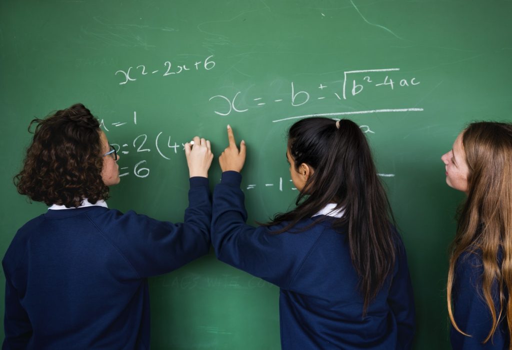 girls writing on a chalk board