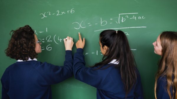 girls writing on a chalk board